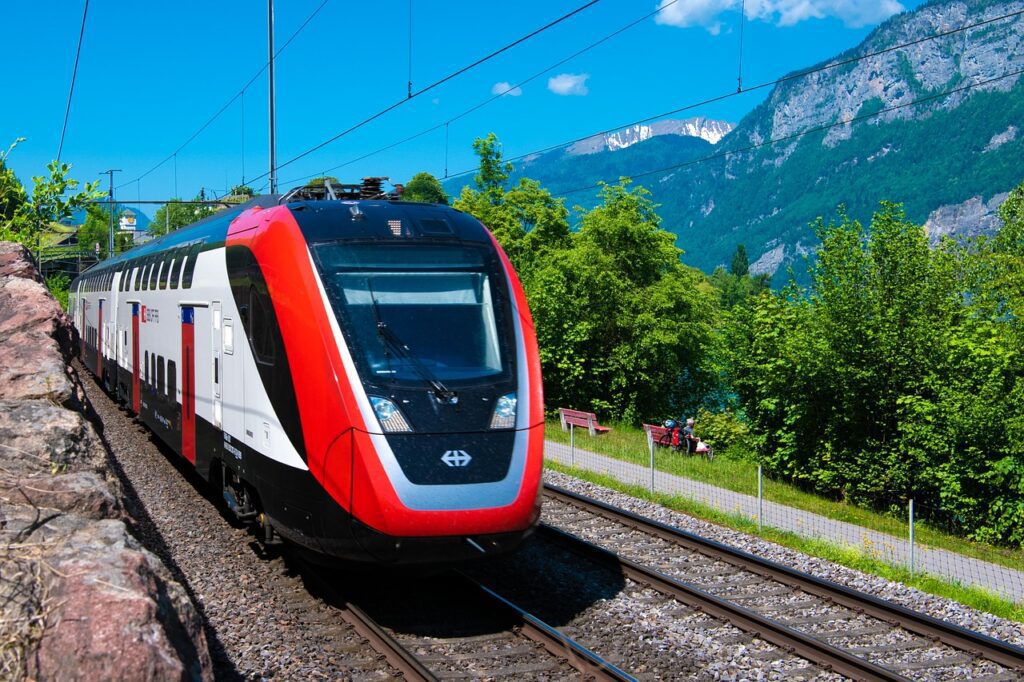 train on train tracks with mountains in background in switzerland